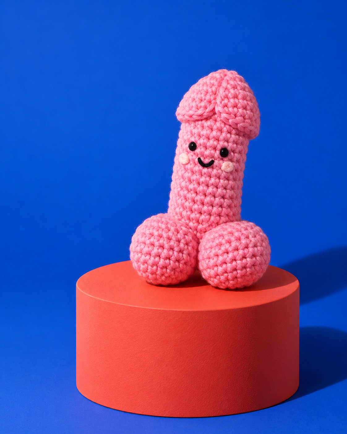 Cazzetto rosa all’uncinetto su piedistallo rosso